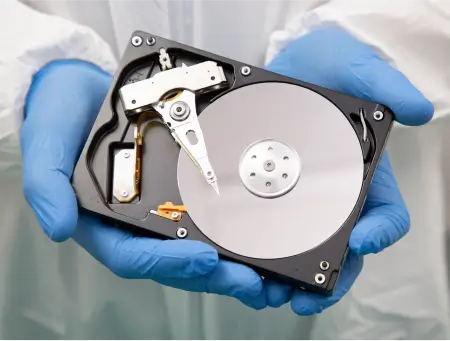 An engineer showing the inside of a hard drive.