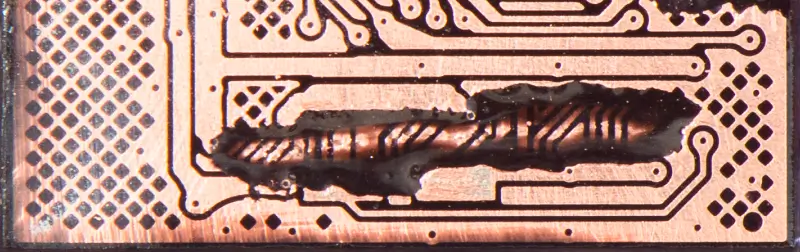 A close-up image of carved out traces buried inside a monolithic chip on a USB flash drive.